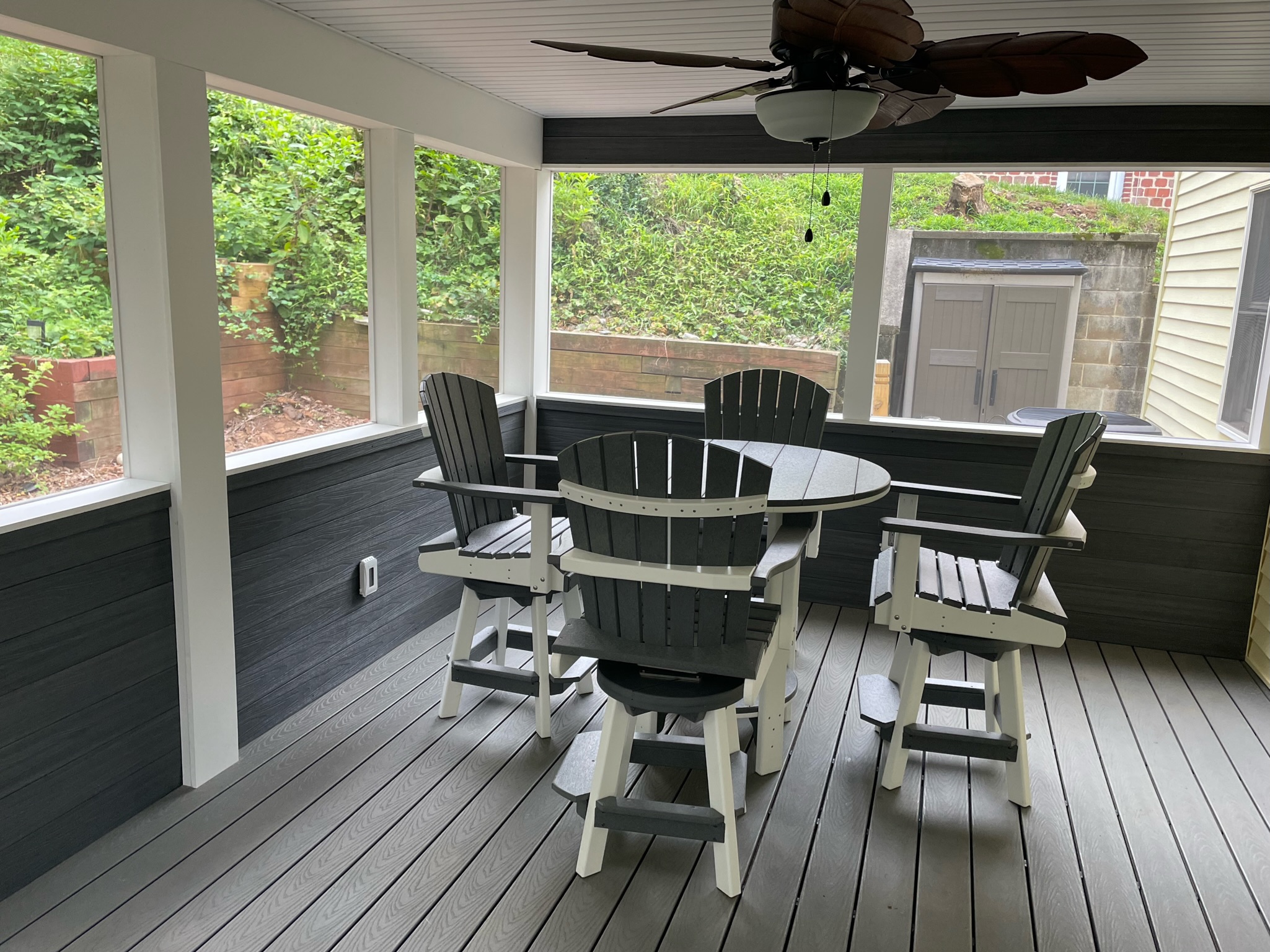 Screened-in deck featuring round table seating and ceiling fan