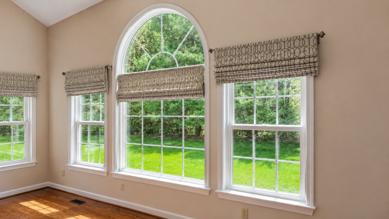 bright room with three large windows and Roman shades overlooking a green lawn